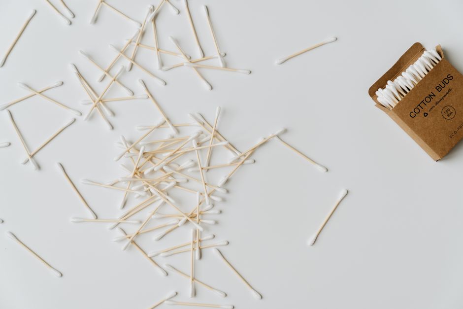 A scattered arrangement of eco-friendly cotton buds on a clean white background in minimal