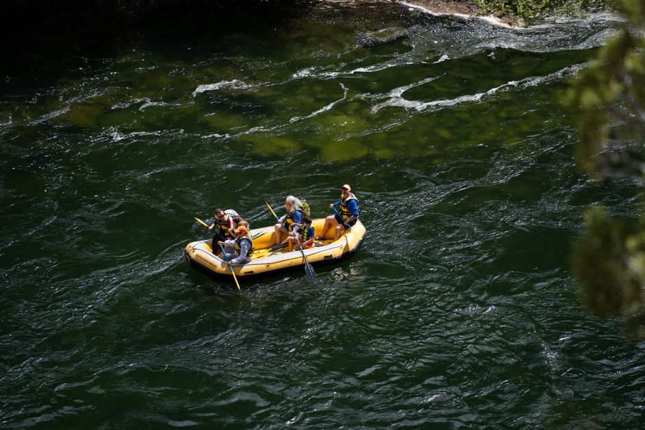 Family enjoying rafting adventure on Green River, Utah, in a yellow inflatable raft.