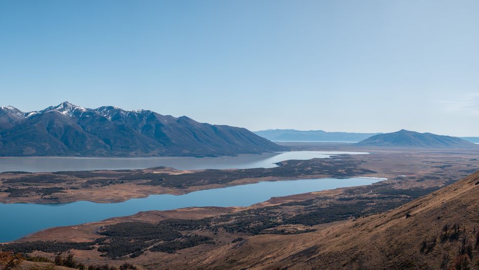 Scenic landscape of mountains and lake in Patagonia, Argentina, under a clear blue sky.