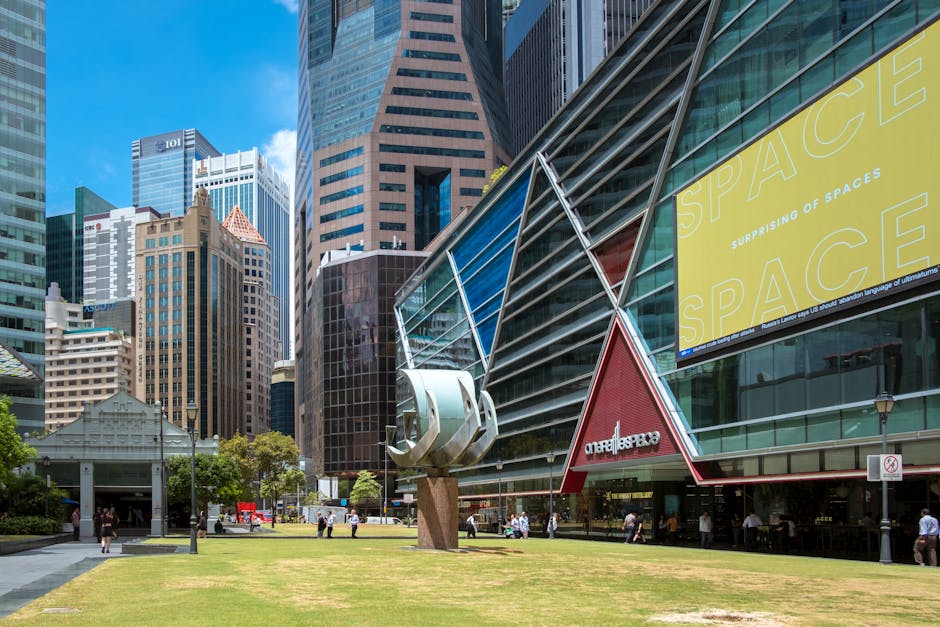 View of modern skyscrapers with a sculpture in the heart of Singapore's CBD during the day.