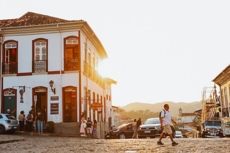 People walking along a colonial street during sunset in a picturesque town.