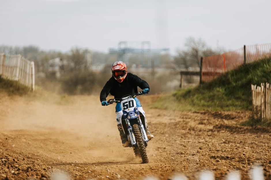 Rider speeds through a dirt track in Germany, showcasing motocross skills and endurance.