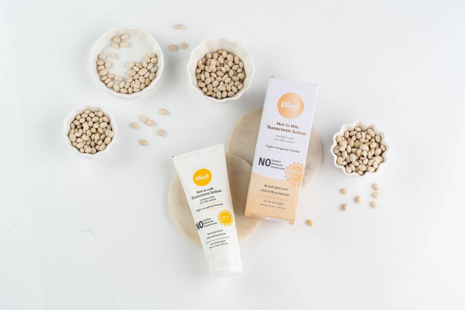 Flat lay image of sunscreen lotion with natural seeds highlighting the skincare product's organic composition.