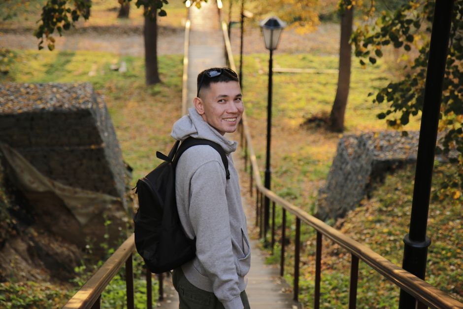 Young man with backpack enjoying a fall day in the forest.