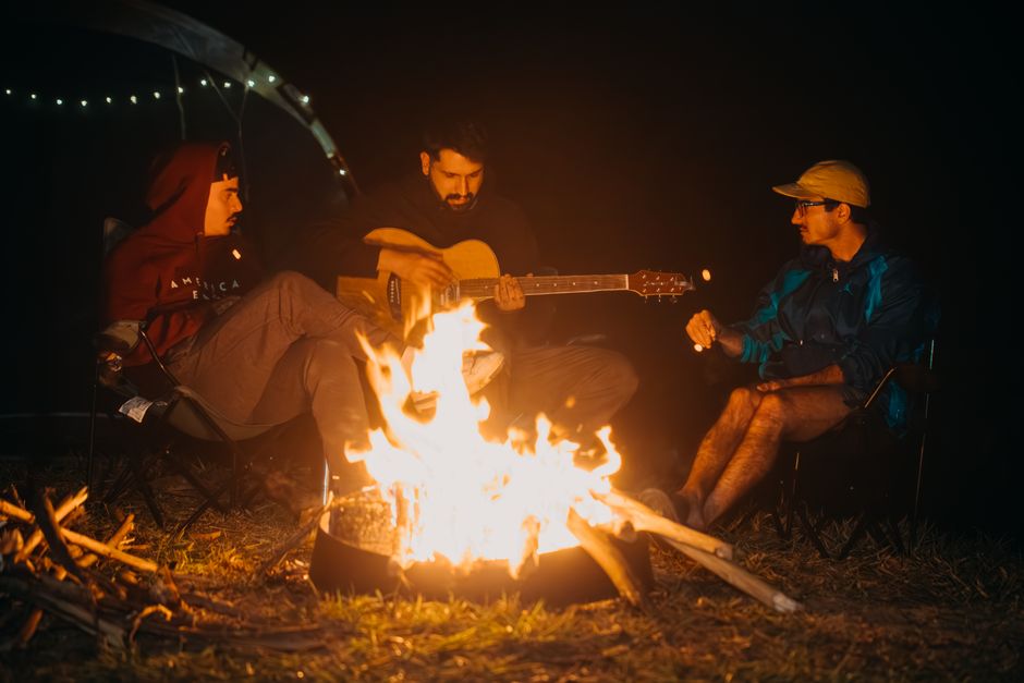 Group enjoying music around a campfire at night in Natividade da Serra, Brazil.