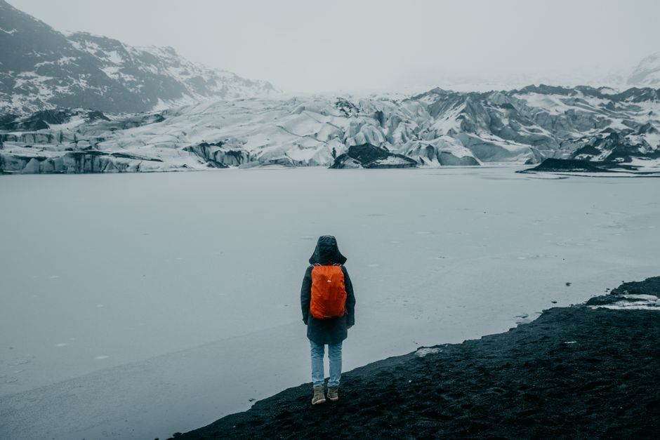 Person standing on a snowy Icelandic landscape, highlighting solitude and winter travel.