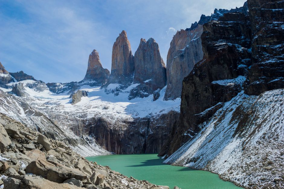 Breathtaking view of Torres del Paine's snow-capped peaks and turquoise lake. Ideal for nature photography enthusiasts.