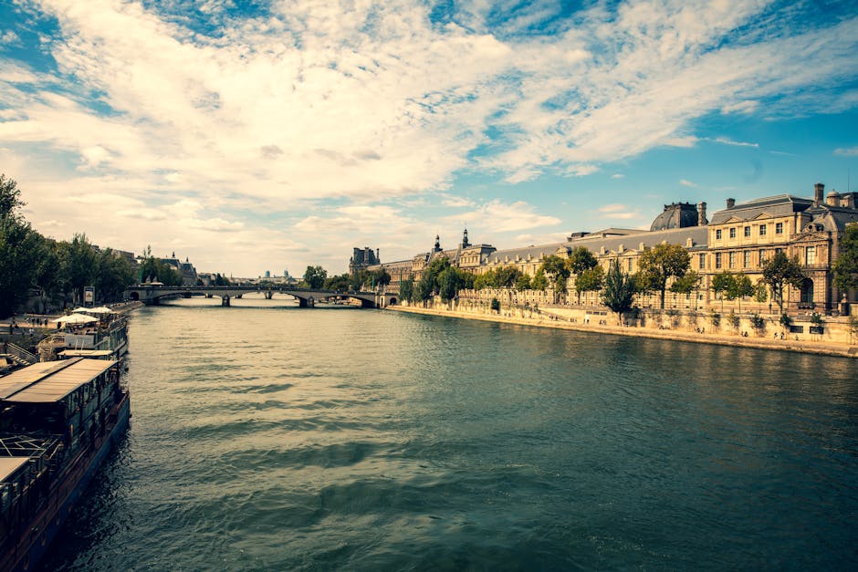 Explore the serene beauty of Paris along the Seine with historic architecture and vibrant skies.