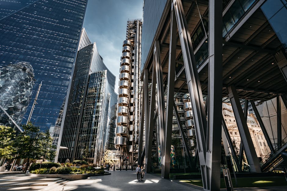 A bustling street view of modern skyscrapers in London's financial district with people walking below.