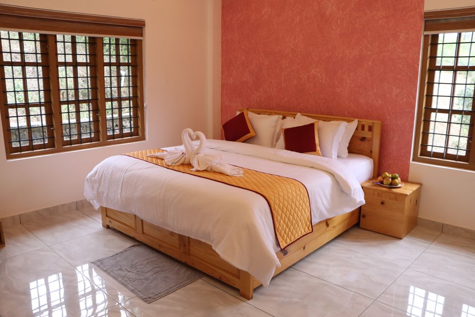 Elegant bedroom in a Vagamon resort featuring a king-sized bed and warm decor. Great for relaxation.
